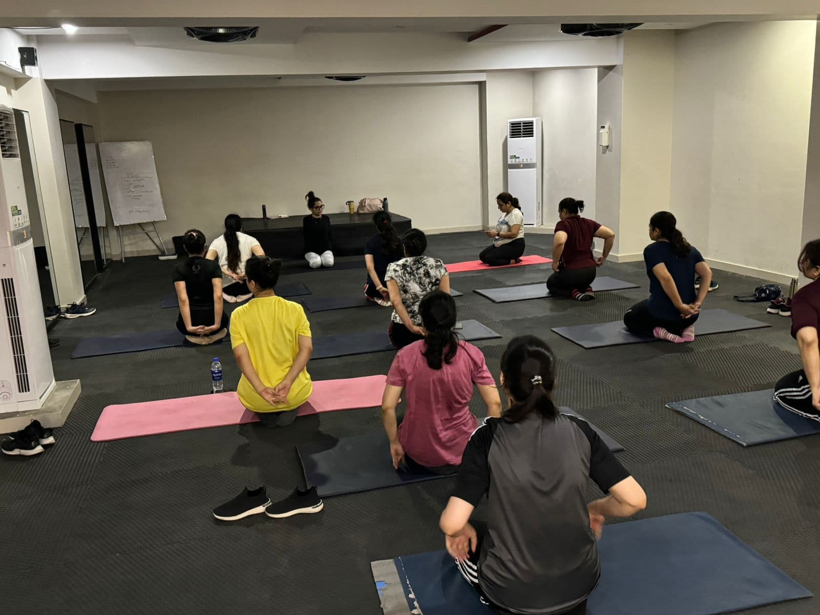 Maha leading a structured, bright group yoga class